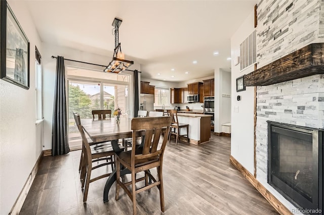 350 N Langdale Ct, Aurora, CO 80018 - dining area featuring a stone fireplace, recessed lighting, wood finished floors, and baseboards