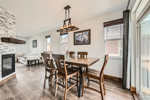 350 N Langdale Ct, Aurora, CO 80018 - dining area with wood finished floors, a stone fireplace, a chandelier, baseboards, and recessed lighting