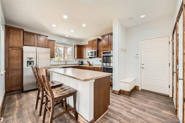 350 N Langdale Ct, Aurora, CO 80018 - kitchen featuring appliances with stainless steel finishes, a sink, dark wood-style floors, recessed lighting, and a kitchen island