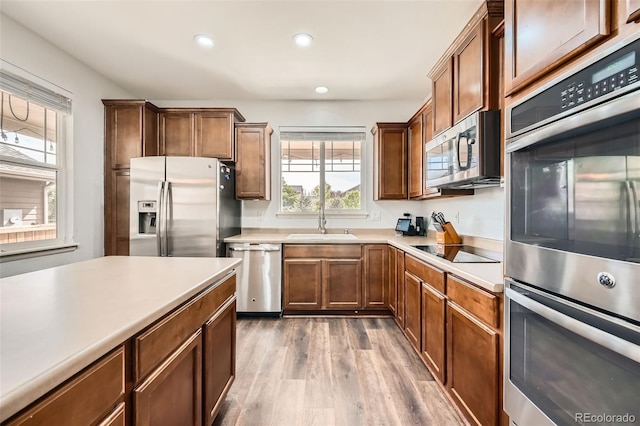 350 N Langdale Ct, Aurora, CO 80018 - kitchen with stainless steel appliances, a sink, wood finished floors, recessed lighting, and light countertops