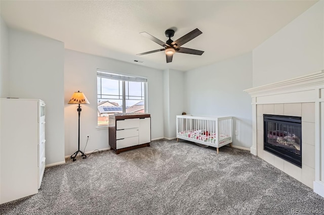 350 N Langdale Ct, Aurora, CO 80018 - bedroom featuring carpet floors, a tiled fireplace, baseboards, ceiling fan, and a nursery area