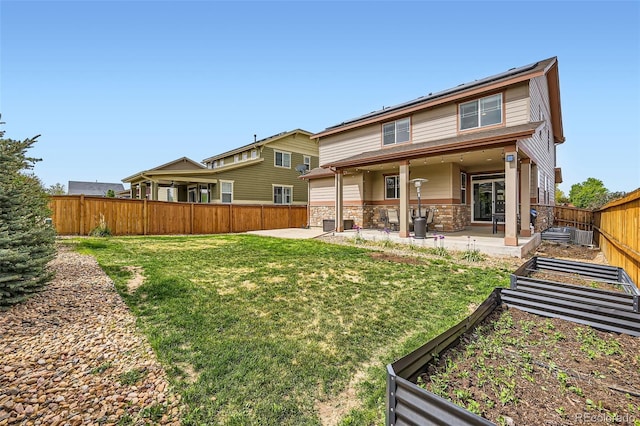 350 N Langdale Ct, Aurora, CO 80018 - back of property featuring a garden, a patio, and stone siding