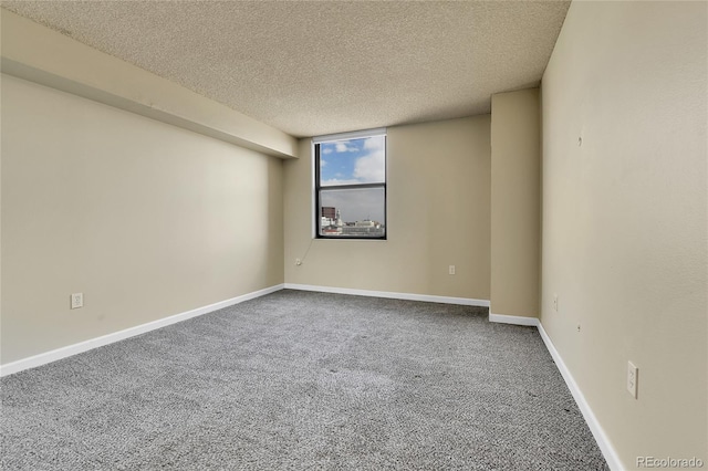 carpeted spare room with baseboards and a textured ceiling