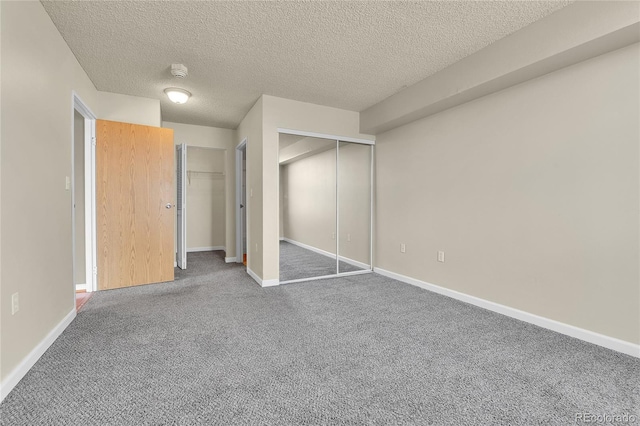 unfurnished bedroom featuring two closets, baseboards, carpet floors, and a textured ceiling