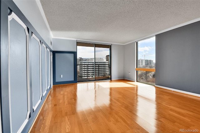 unfurnished bedroom with a wall of windows, multiple windows, wood finished floors, and ornamental molding