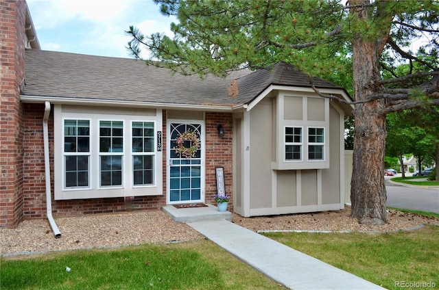 9713 W Chatfield Ave Unit H, Littleton, CO 80128 - view of front facade featuring a shingled roof and stucco siding