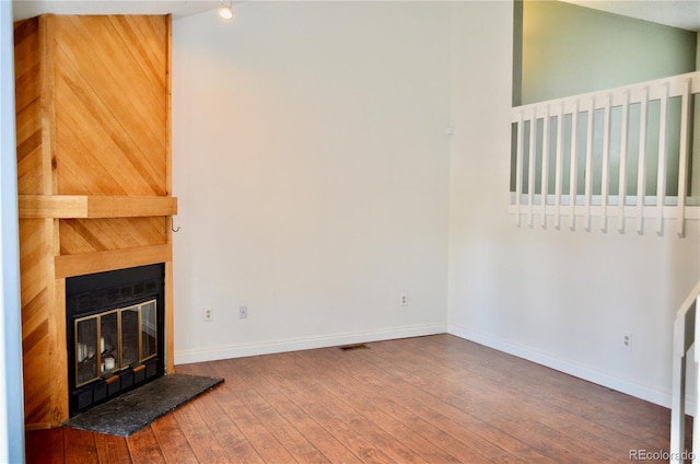 9713 W Chatfield Ave Unit H, Littleton, CO 80128 - unfurnished living room featuring wood-type flooring and a fireplace