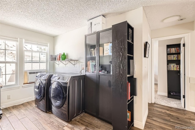 9713 W Chatfield Ave Unit H, Littleton, CO 80128 - laundry room with a textured ceiling, washing machine and clothes dryer, wood finished floors, and cooling unit