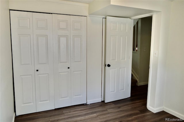 9713 W Chatfield Ave Unit H, Littleton, CO 80128 - unfurnished bedroom featuring dark wood-type flooring and a closet