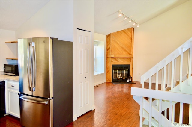 9713 W Chatfield Ave Unit H, Littleton, CO 80128 - kitchen with freestanding refrigerator, black microwave, rail lighting, wood finished floors, and lofted ceiling