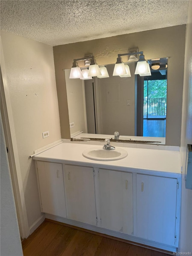 8060 E Girard Ave Unit 504, Denver, CO 80231 - bathroom with vanity, a textured ceiling, and wood finished floors