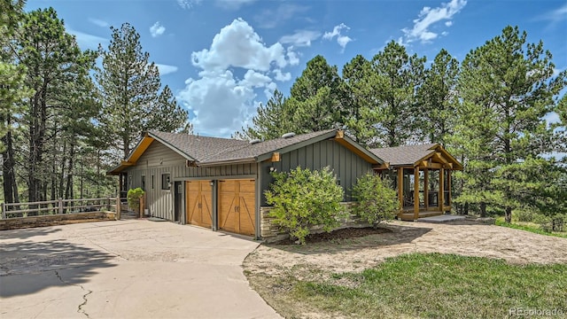 2231 Meadow Green Cir, Franktown, CO 80116 - view of front of home featuring board and batten siding, a garage, a shingled roof, driveway, and french doors