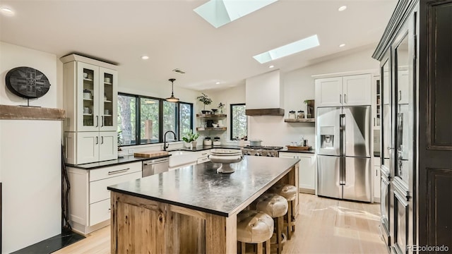 2231 Meadow Green Cir, Franktown, CO 80116 - kitchen with stainless steel appliances, open shelves, a skylight, dark countertops, and vaulted ceiling