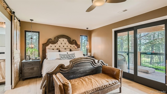 2231 Meadow Green Cir, Franktown, CO 80116 - bedroom with access to exterior, light wood-style floors, a barn door, and ceiling fan