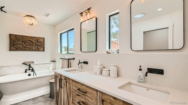 2231 Meadow Green Cir, Franktown, CO 80116 - bathroom featuring healthy amount of natural light, a freestanding bath, and double vanity