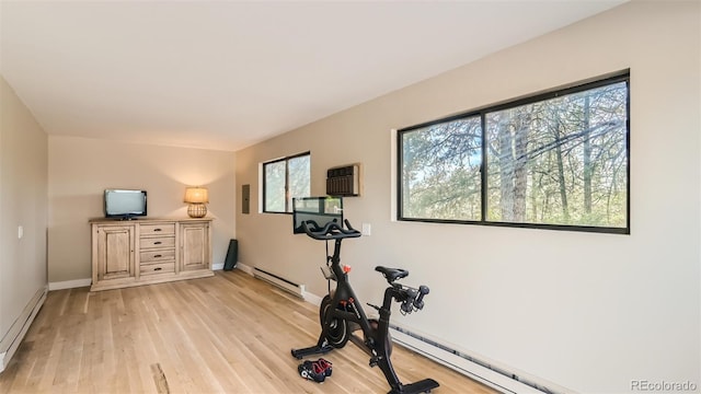 2231 Meadow Green Cir, Franktown, CO 80116 - workout room featuring baseboard heating, light wood-style flooring, a baseboard radiator, and an AC wall unit