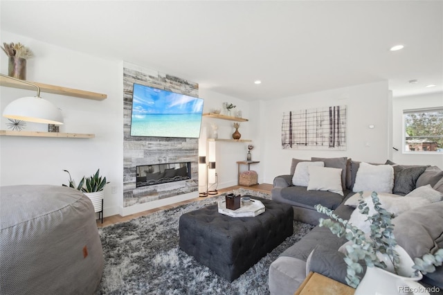 living room with hardwood / wood-style flooring and a large fireplace