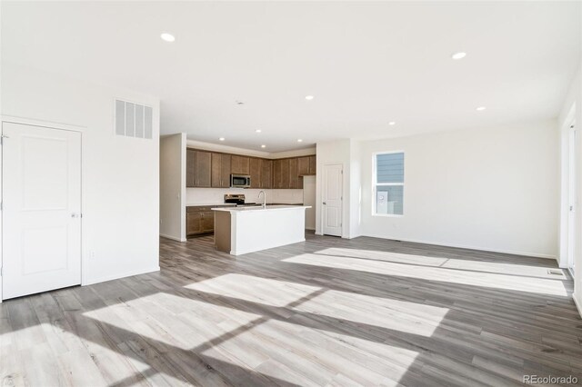 13412 E 110th Way, Commerce City, CO 80022 - unfurnished living room featuring light wood-style flooring and recessed lighting