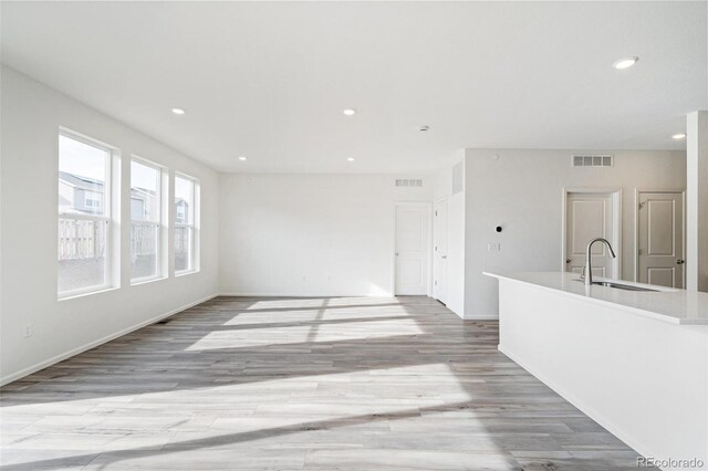 13412 E 110th Way, Commerce City, CO 80022 - unfurnished living room with light wood-style floors and recessed lighting