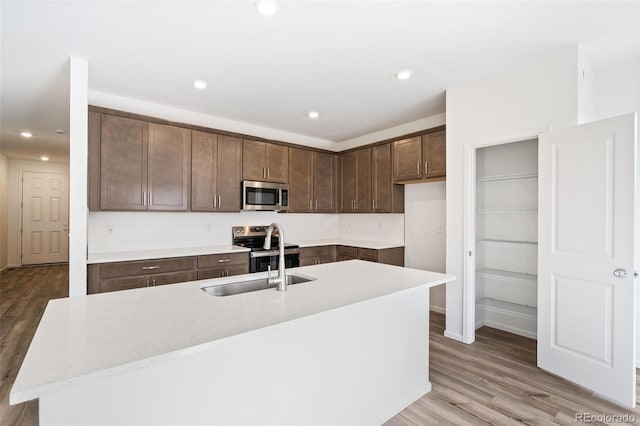 13412 E 110th Way, Commerce City, CO 80022 - kitchen featuring stainless steel appliances, light wood finished floors, light countertops, recessed lighting, and dark brown cabinets