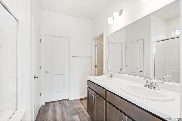13412 E 110th Way, Commerce City, CO 80022 - full bathroom featuring wood finished floors, double vanity, and a tile shower