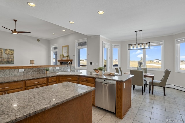 kitchen featuring light stone countertops, stainless steel dishwasher, sink, a center island with sink, and hanging light fixtures