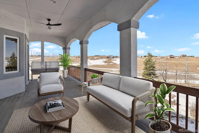 wooden terrace featuring outdoor lounge area and a ceiling fan