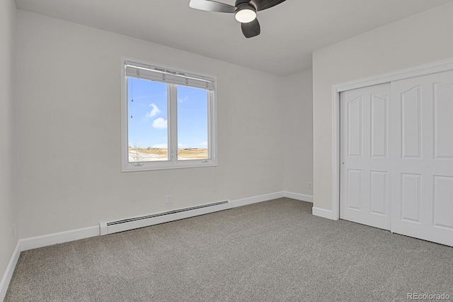 unfurnished bedroom featuring carpet flooring, ceiling fan, baseboard heating, and a closet