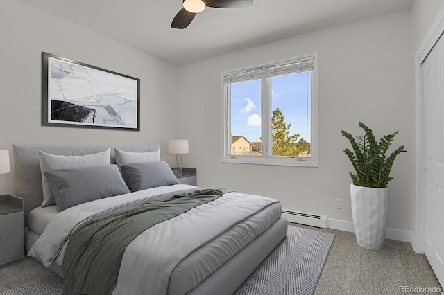 bedroom with a baseboard heating unit, carpet floors, a ceiling fan, baseboards, and a closet