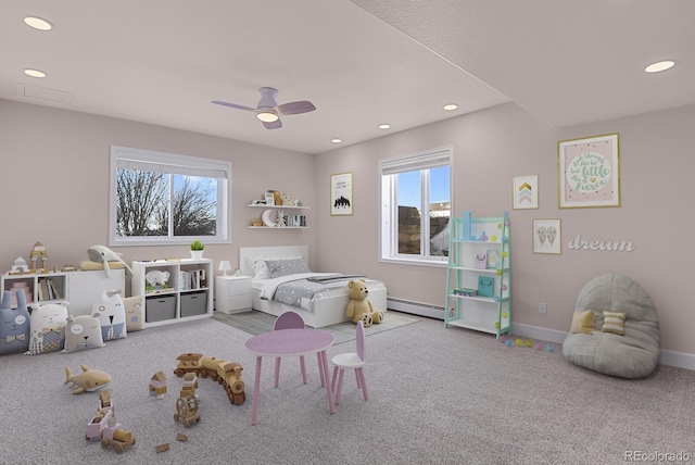 bedroom featuring light colored carpet, multiple windows, a baseboard heating unit, and ceiling fan