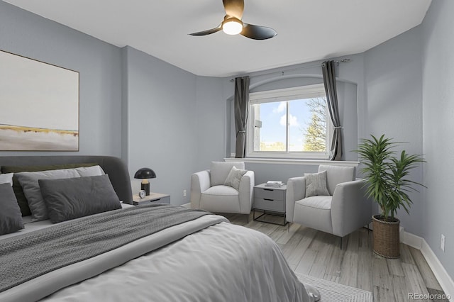 bedroom featuring ceiling fan, baseboards, and wood finished floors