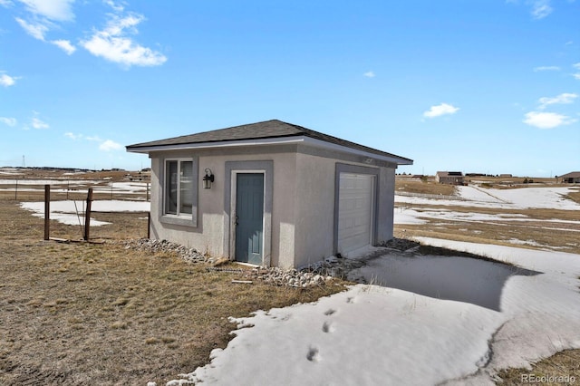 snow covered structure featuring a garage