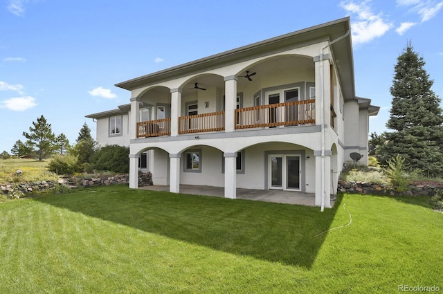 rear view of property with a patio, a balcony, ceiling fan, and a lawn