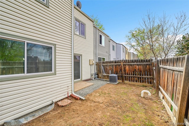 fenced backyard featuring central AC