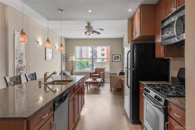 1975 Grant St Unit 501, Denver, CO 80203 - kitchen with stainless steel appliances, light wood-type flooring, brown cabinets, a ceiling fan, and recessed lighting