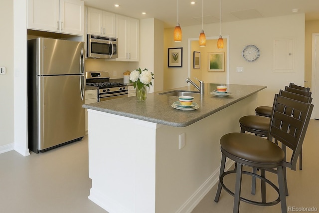 1975 Grant St Unit 501, Denver, CO 80203 - kitchen featuring appliances with stainless steel finishes, a kitchen breakfast bar, white cabinets, dark countertops, and recessed lighting