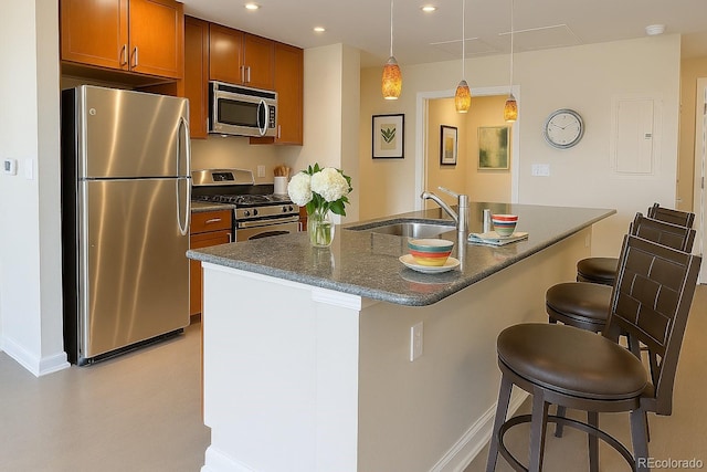 1975 Grant St Unit 501, Denver, CO 80203 - kitchen featuring stainless steel appliances, brown cabinetry, a breakfast bar, recessed lighting, and pendant lighting