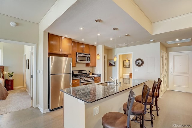 1975 Grant St Unit 501, Denver, CO 80203 - kitchen with appliances with stainless steel finishes, brown cabinetry, dark stone countertops, a breakfast bar area, and light wood-style flooring