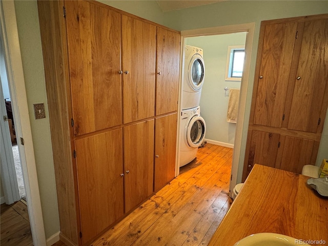 700 County Road 150, Westcliffe, CO 81252 - washroom with stacked washing machine and dryer, light wood finished floors, and baseboards