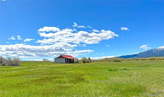 700 County Road 150, Westcliffe, CO 81252 - view of green lawn featuring a view of rural / pastoral area, an outdoor structure, a mountain view, and a pole building
