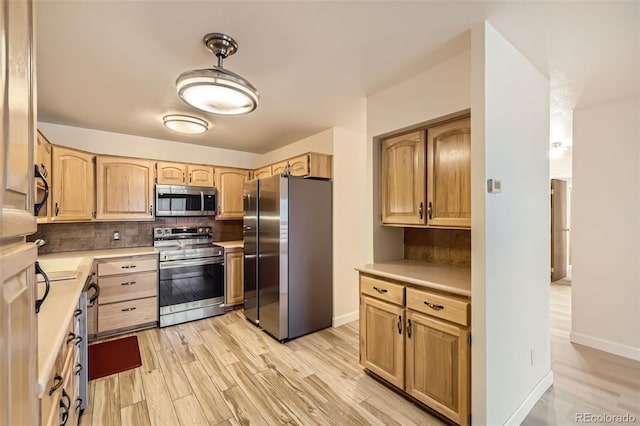 kitchen featuring backsplash, light brown cabinets, stainless steel appliances, and light countertops