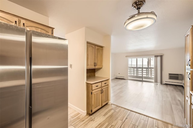 kitchen featuring a baseboard heating unit, light countertops, an AC wall unit, light wood-type flooring, and freestanding refrigerator