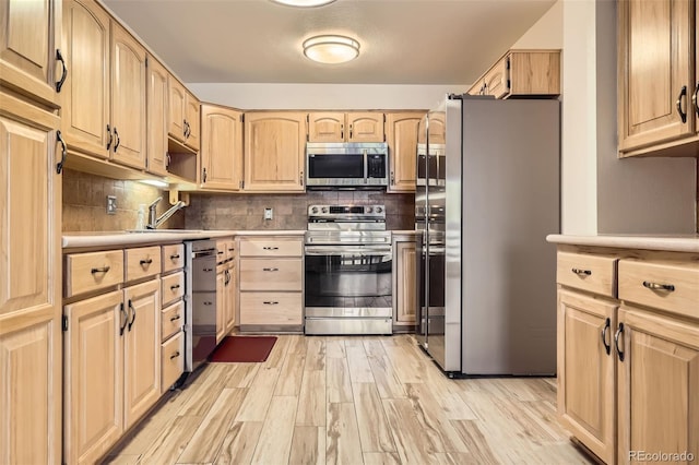 kitchen with light wood-style floors, appliances with stainless steel finishes, light countertops, and light brown cabinetry