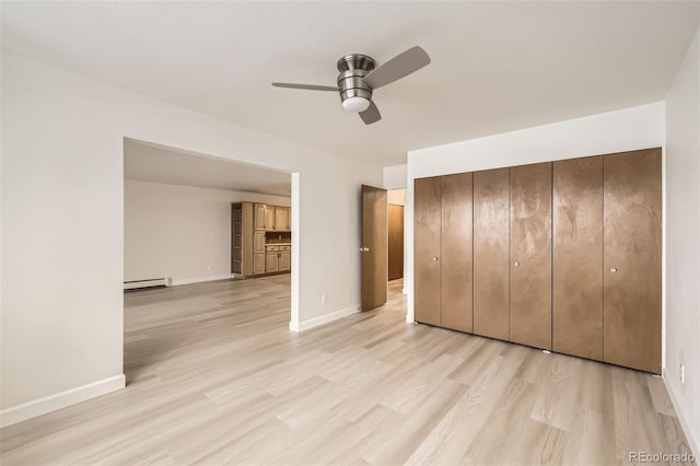 unfurnished bedroom featuring a ceiling fan, a closet, baseboards, and light wood finished floors