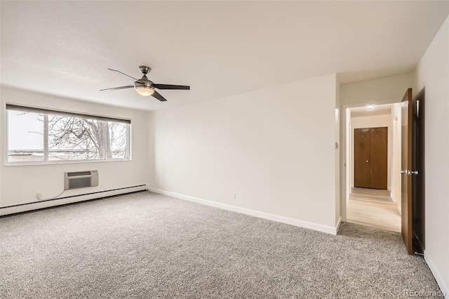 spare room with a wall unit AC, carpet, baseboards, and a ceiling fan