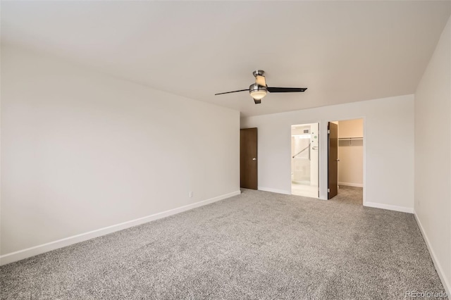 unfurnished bedroom with ceiling fan, carpet flooring, baseboards, a closet, and a walk in closet