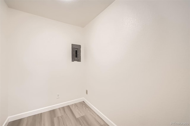 laundry area featuring light wood-type flooring, laundry area, electric panel, and baseboards