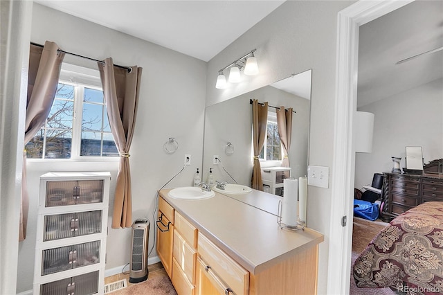 bathroom featuring visible vents, baseboards, vanity, and a healthy amount of sunlight