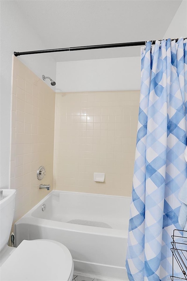 bathroom featuring shower / bath combo and toilet