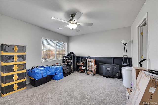 bedroom with ceiling fan, carpet floors, and a wainscoted wall